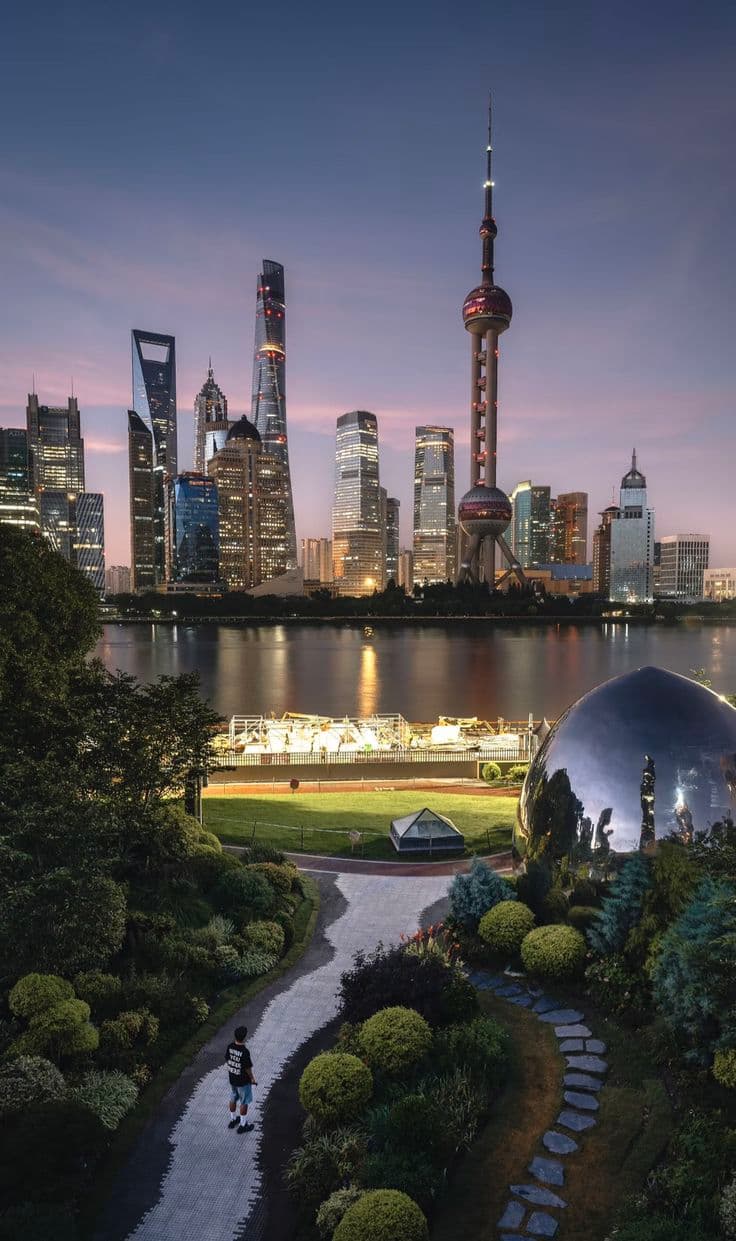 Shanghai Bund Waterfront at golden hour with Pudong skyline reflected in the Huangpu River